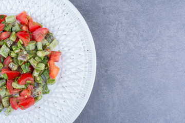 Vegetable salad with tomatoes and green beans inside a dish
