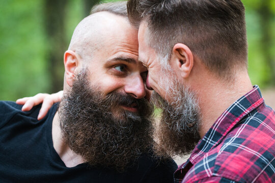Long Beard Hipster Gay Couple Romantically Posing With Confidence In The Woods. Male Homosexual Partners In Late 30s, Attractive And Fashionable Look And Haircuts.