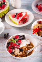 Granola, muesli cereals with yogurt or milk and fresh berries. Healthy breakfast concept.