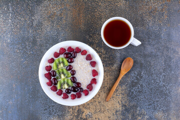 Milky porridge with fruits, berries and a cup of drink