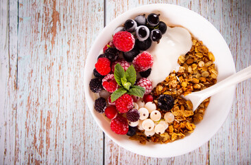 Granola, muesli cereals with yogurt or milk and fresh berries. Healthy breakfast concept.