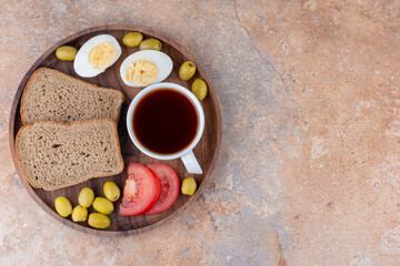Breakfast paltter with bread and a cup of tea