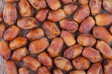 Yellow dry dates on a platter on concrete background