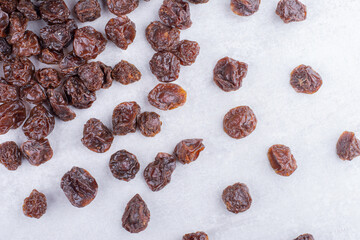 Brown dried cherries isolated on concrete background