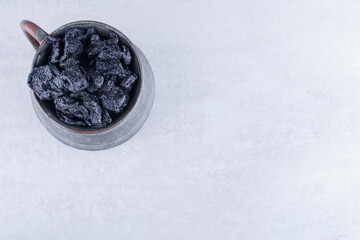 Black dried sultanas isolated on concrete background