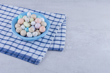 Multicolor candy balls in a platter on concrete background