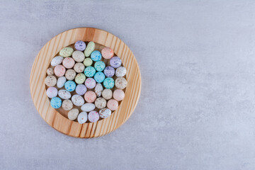 Multicolor candy balls in a platter on concrete background