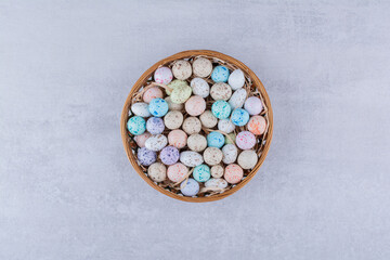 Multicolor candy balls in a platter on concrete background