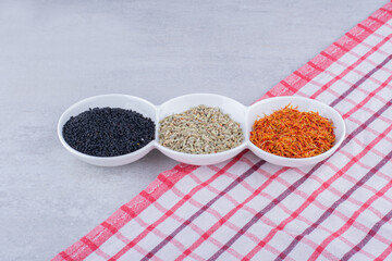 Black cumin, anise seeds and saffron in white saucers