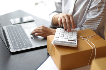 Female operator calculates the cost of goods before shipping.