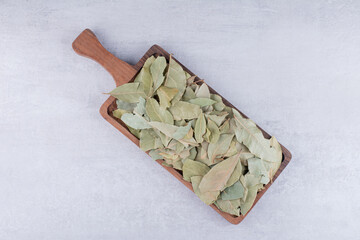 Dry bay leaves on a wooden platter