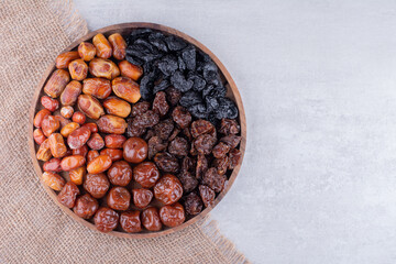 Dry fruits set with dates and cherries on a wooden platter