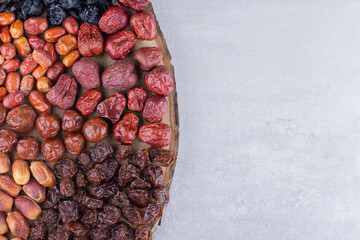 Dried cherries, berries and dates on a wooden platter
