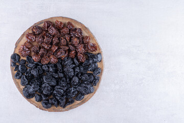 Dried black sultana and cherries on a wooden platter