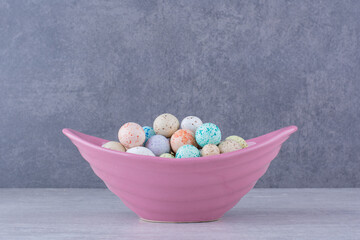 Colorful stone candies in trays on concrete background