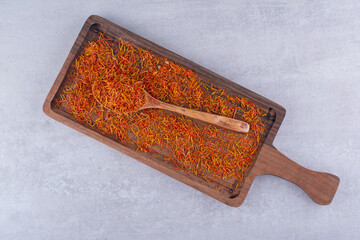 Red saffron seeds isolated on a wooden platter