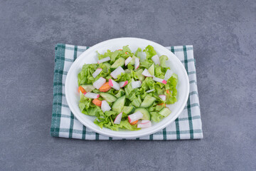 Green salad in a plate on blue background