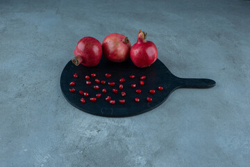 Red pomegranates isolated on a black platter