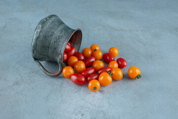 Red and yellow cherry tomatoes in a metallic pot