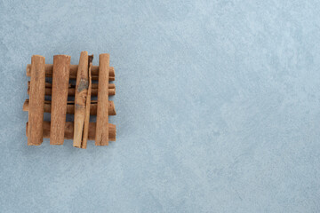 Cinnamon sticks in a pile on blue background