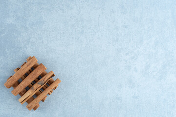 Cinnamon sticks in a pile on blue background
