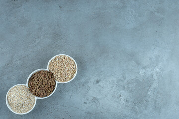 Sunflower, pumpkin seeds and rice grains in white cups