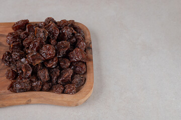 Brown dried cherries on a wooden platter
