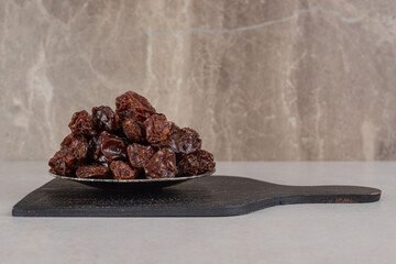 Brown dried cherries on a wooden platter