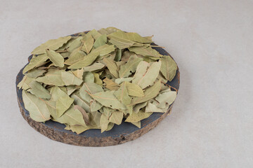 Dried green bay leaves on a wooden platter