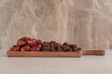 Dates and dry plums on a wooden platter