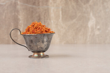 Red saffron plant in a cup on concrete background
