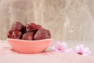 Dry jujube berries in a cup on concrete background