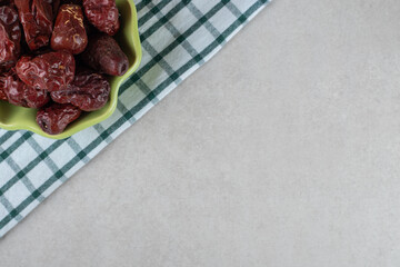 Dried Indian jujube berries in a cup on concrete background