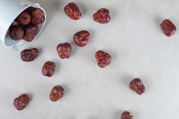 Dried Indian jujube berries in a cup on concrete background