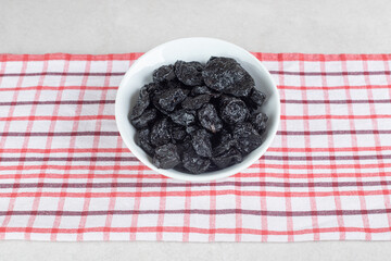 Dried black plums in a ceramic dish
