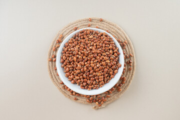 Brown raw beans in a platter on concrete background
