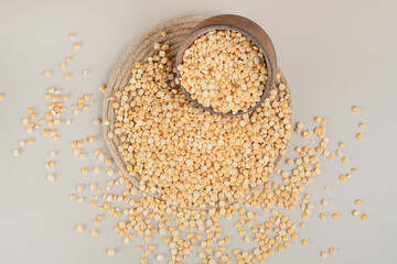 Yellow pea beans in a wooden cup on concrete background