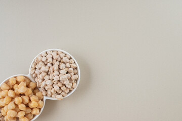 Raw and cooked or boiled pea beans in ceramic cups