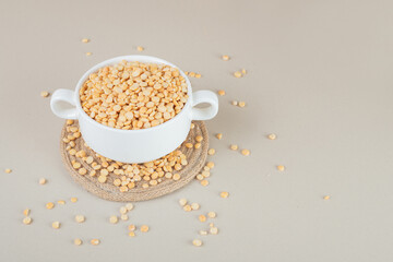 Yellow pea beans in a ceramic cup on concrete background