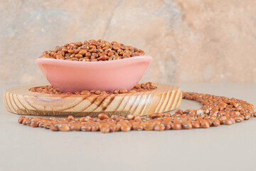 Brown beans isolated in a ceramic cup on concrete background