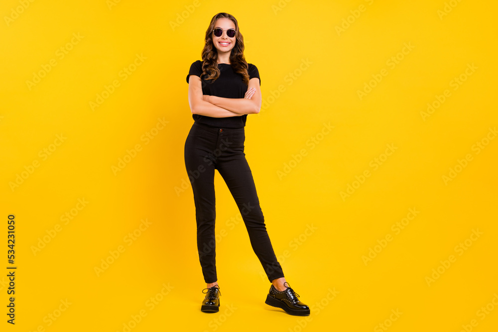 Wall mural full length photo of young charming woman standing confident eyewear isolated over yellow color back