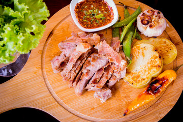 Grilled rib eye steak on the wood plate with Vegetables and spicy sauce