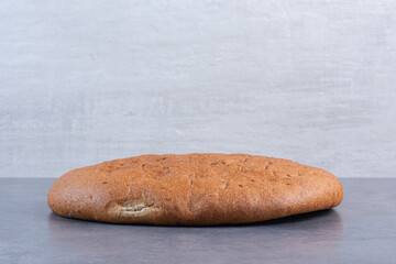 Crisp round loaf of bread on marble background