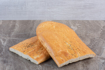 Stacked loaves of crisp half-sliced tandoori bread on marble background