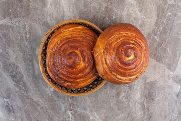 Two sweet buns and a small basket on marble background