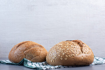Bread loaves with various coatings on a towel on marble background