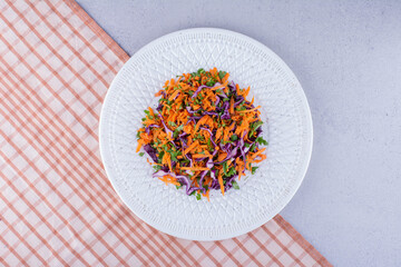 Portion of cabbage and carrot salad on marble background