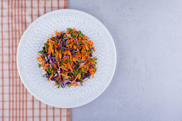 Appetizer portion of cabbage and carrot salad on marble background