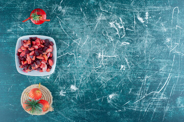 Arrangement of christmas baubles and a platter of vinegret salad on blue background