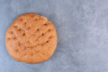 Crisp round loaf of bread on marble background